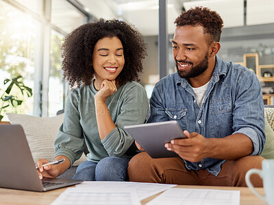 Buy stock photo Young happy mixed race couple going through documents and using a digital tablet and laptop at a table together at home. Hispanic husband and wife smiling while planning and paying bills. Boyfriend and girlfriend working on their budget