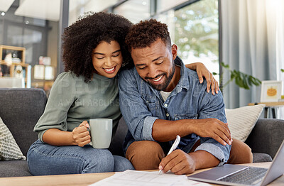 Buy stock photo Young mixed race couple going through bills and using a laptop at a table together at home. Husband and wife planning and working on documents
