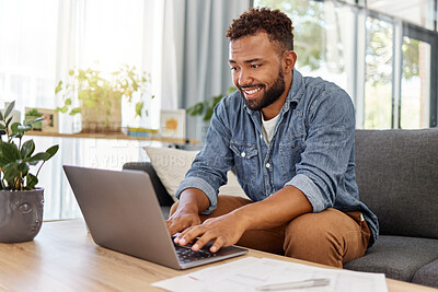 Buy stock photo Young mixed race man working on filling out forms while typing on a laptop at home. One hispanic man planning and sending an email alone in the lounge at home