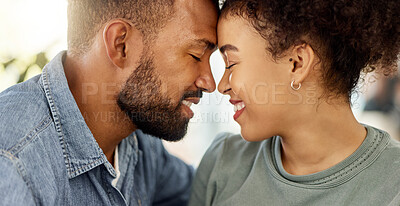 Buy stock photo Content mixed race couple smiling while relaxing at home. Carefree hispanic husband and wife bonding together in the lounge at home