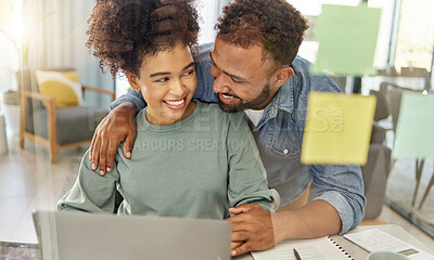 Buy stock photo Happy mixed race couple working on a laptop together at a table at home. Cheerful hispanic boyfriend and girlfriend hugging while planning and reading an email in the lounge at home