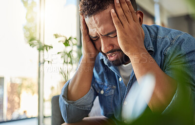 Buy stock photo Young man with a headache at home. Young bachelor with a migraine in his apartment.Stressed young man in his lounge. Young man suffering with anxiety having a breakdown crisis alone