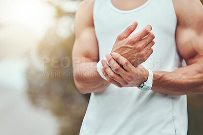 Buy stock photo One unknown mixed race tennis player suffering from wrist injury in court game. Hispanic fit professional in pain while holding and rubbing hand after match. Sporty man standing alone in sports club