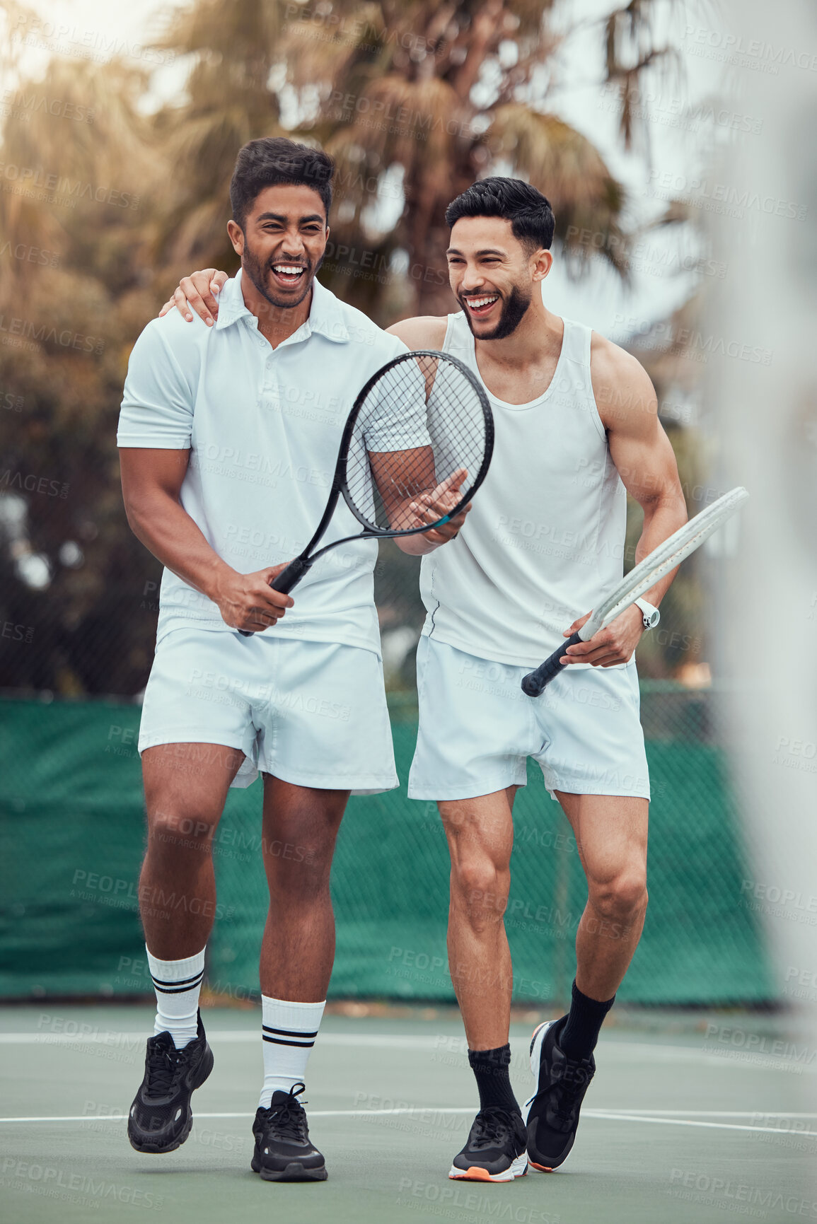 Buy stock photo Full length two ethnic tennis players holding rackets and bonding playing court game. Smiling athletes team together after match. Play competitive doubles match for fitness and health in sports club