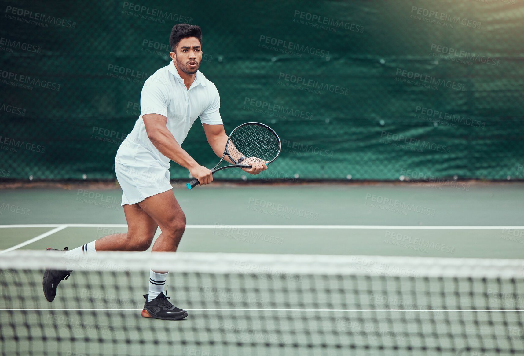 Buy stock photo Full length of indian tennis player holding a racket and playing a game on court. Fit ethnic athlete running during a match. Playing competitive sports for fitness and health alone in a sports club
