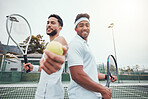 Two ethnic tennis players holding ball as invite to play court game. Smiling ethnic athletes team standing back to back. Challenge to play competitive sports doubles for healthy fitness in sports club