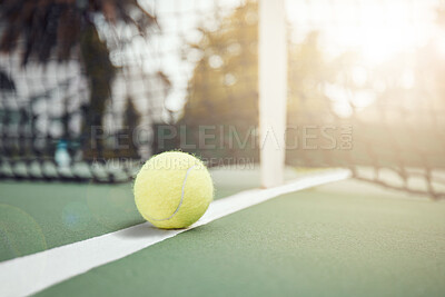 Closeup of one yellow tennis ball on the floor after hitting a net during a game on a court. Still life ball on a line during a competitive sports match in a sports club. Losing by touching the net