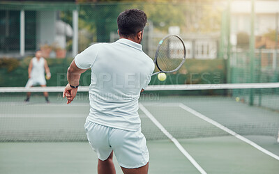 Buy stock photo Two ethnic tennis players holding rackets and playing court game. Rear view of unknown team of athletes together during match. Playing competitive doubles match for fitness and health in sports club