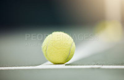 Closeup of one yellow tennis ball on the floor during a game on a court. Macro still life ball on white line during a competitive sports match in a sports club. Losing and out by touching the marking