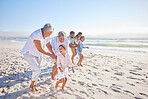 Grandparents playing with adorable grandson on beach. Muti generation family enjoying vacation by the sea
