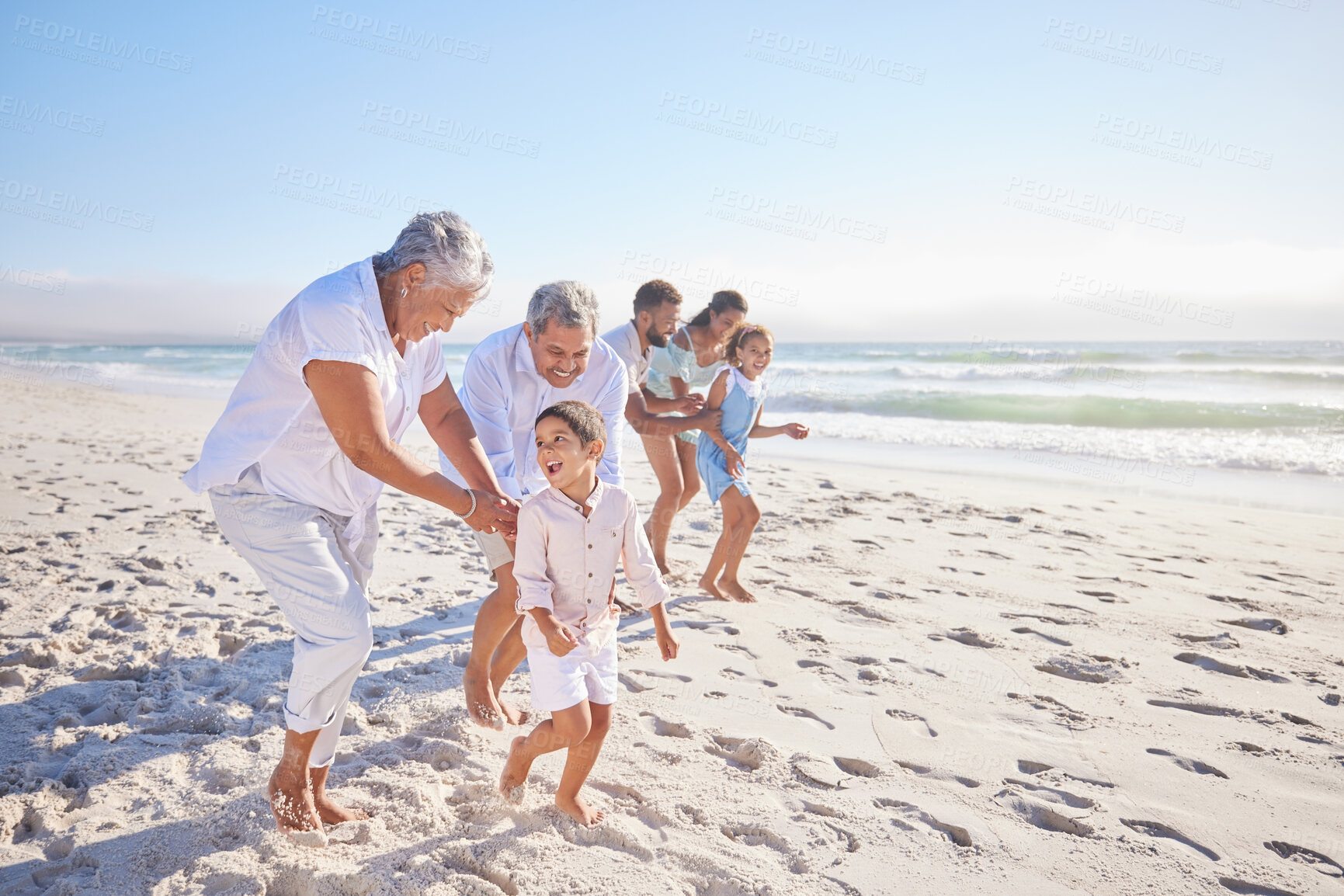 Buy stock photo Vacation, travel and big family running on the beach for playing, bonding and spending quality time. Happy, excited and children having fun with their grandparents and parents by the ocean on holiday
