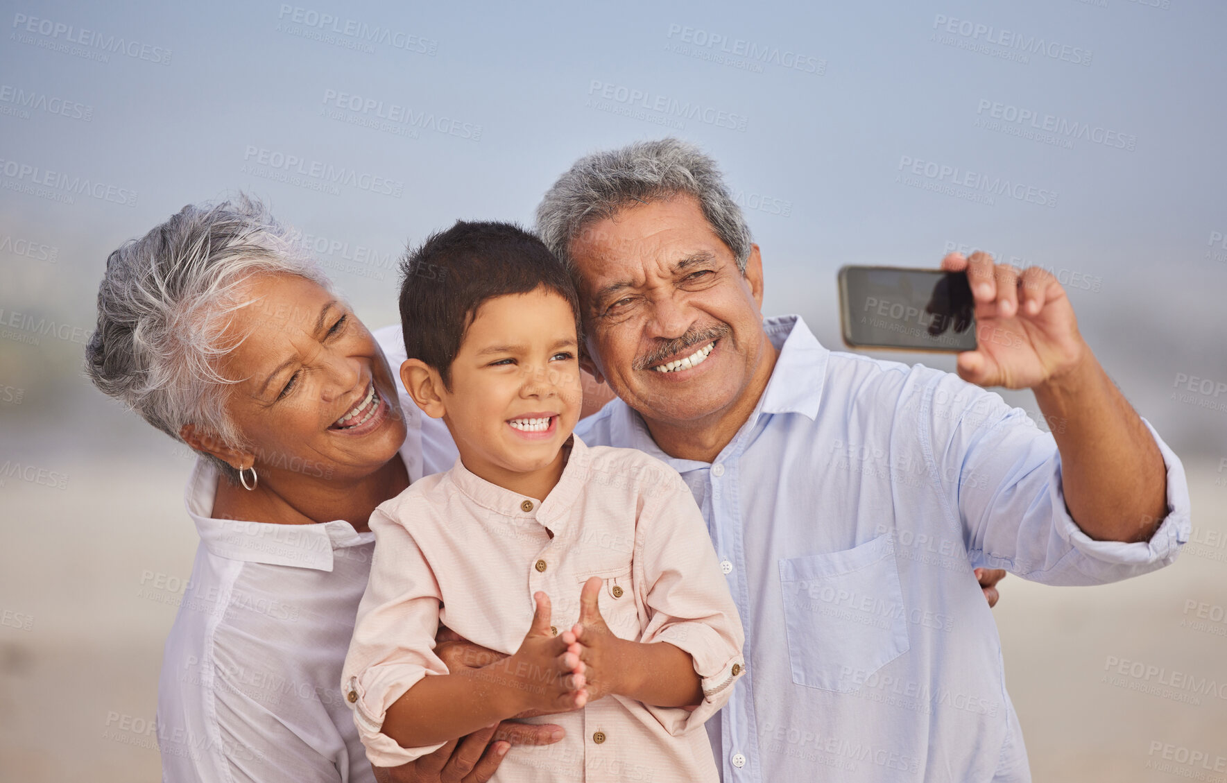 Buy stock photo Selfie, happy and grandparents with child at beach for vacation, bonding and generations. Picture, travel and young boy with senior man and woman in nature for smile, happiness and technology