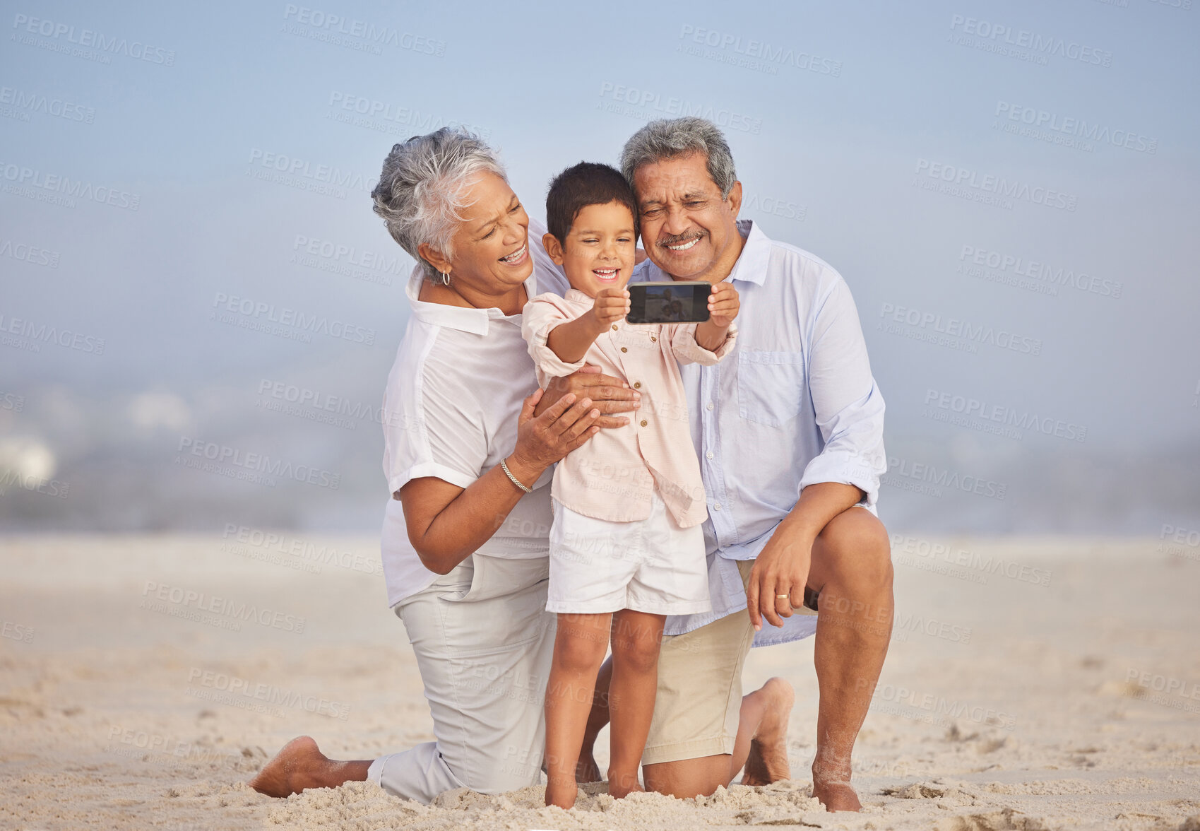 Buy stock photo Selfie, travel and grandparents with child at beach for vacation, bonding and generations. Picture, happy and young boy with senior man and woman in nature for smile, happiness and technology