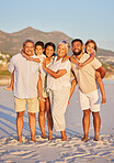 Portrait of a multi generation family on vacation standing together at the beach on a sunny day. Mixed race family with two children, two parents and grandparents spending time together