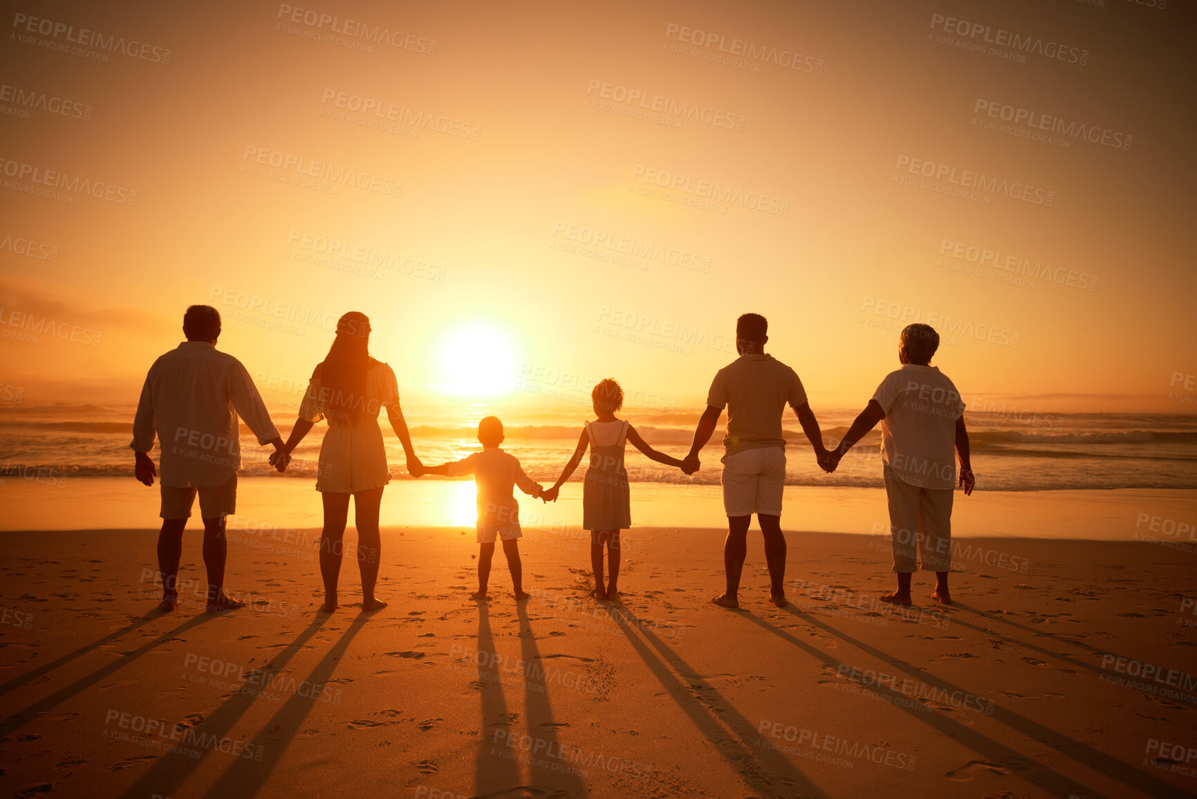 Buy stock photo Family, holding hands beach at sunset and solidarity, grandparents travel with parents and kids with orange sky. Back, generations and men, women and children outdoor with silhouette and vacation