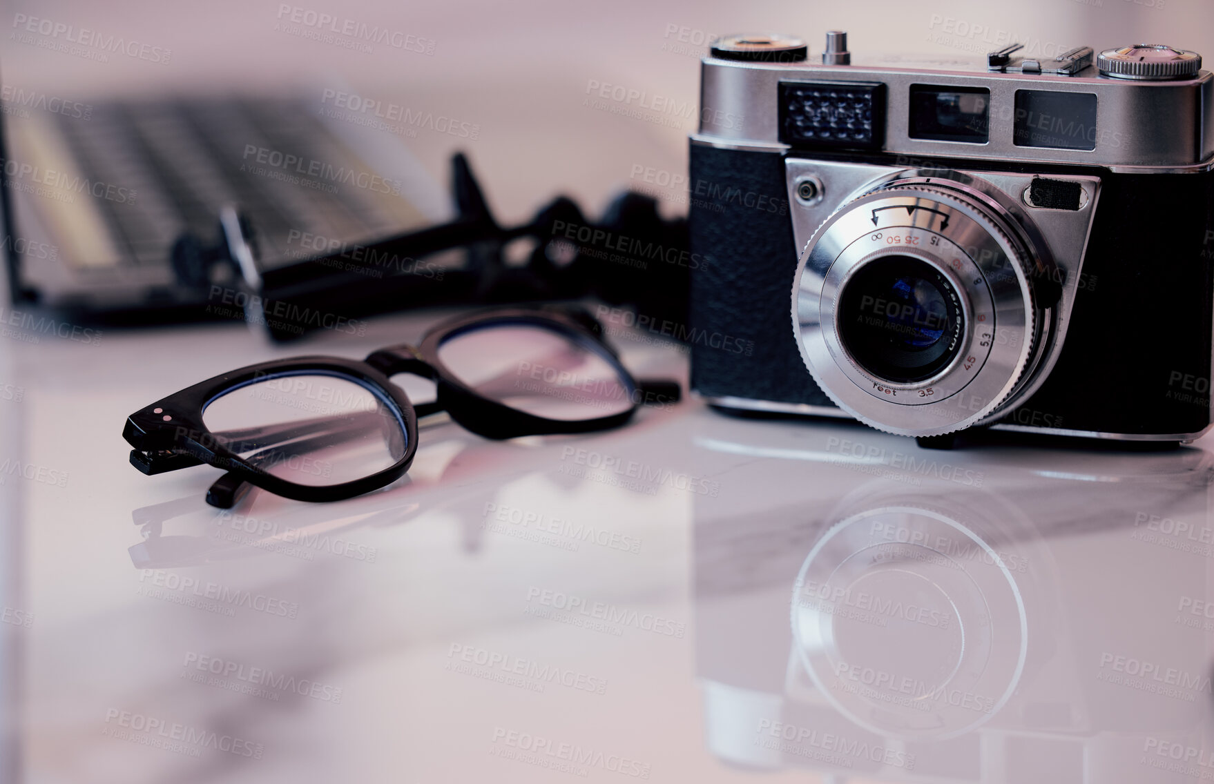 Buy stock photo Closeup, desk and photography studio with camera, glasses and computer for art, journalist or news company. Retro equipment, spectacles and professional lens with laptop in office for newspaper job