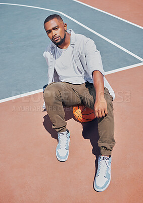 Buy stock photo Fashion, basketball court and model influencer or man posing on a court in an urban city with fashionable style. Male portrait of trendy, stylish and cool person in sports promotion for ball game