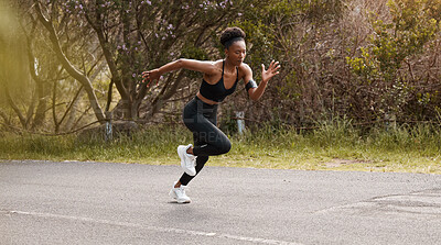 One african american female athlete looking focused while out for run to increase her cardio and endurance. A young black woman sprinting outside to increase her speed and pace. Fitness is a lifestyle