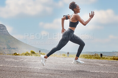 One african american female athlete looking focused while out for run to increase her cardio and endurance. A young black woman running outside to increase her speed and pace. Fitness is a lifestyle