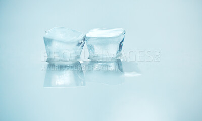Pics of Two ice blocks melting side by side against a blue background in studio. A symbol of global warming as an environmental risk and concern. UV protection is needed during the hot season of summer, stock photo, images and stock photography PeopleImag