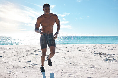 Buy stock photo Fit young black man running and jogging on sand at the beach in the morning for exercise. One strong male bodybuilder athlete with six pack abs doing cardio workout to build muscle and endurance