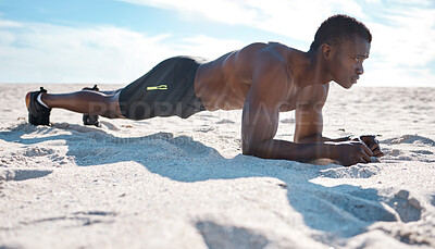Buy stock photo Fit young black man doing plank hold exercises on sand at the beach in the morning. One muscular male bodybuilder athlete with six pack abs doing bodyweight workout to build strong core and endurance