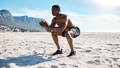 Buy stock photo Fit young black man doing squat exercises on sand at the beach in the morning. One muscular male bodybuilder athlete with six pack abs doing bodyweight workout to build strong core, tone and endurance
