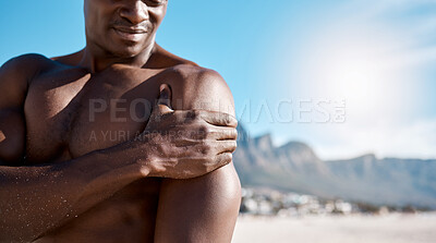 Buy stock photo Closeup shot of an african american muscular athletic man holding his shoulder in pain. Black unrecognizable male suffering from arthritis in his arm. Suffering from a hurting, stiff, injured joint