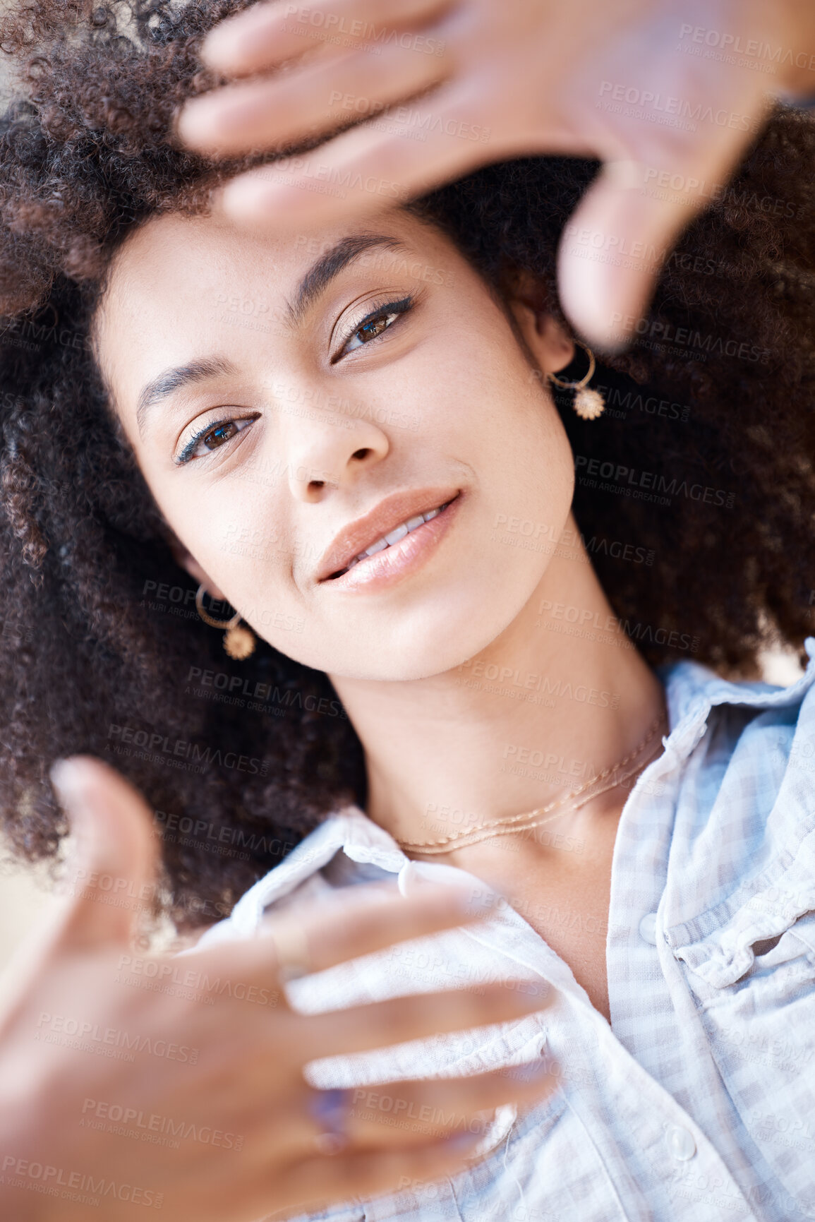Buy stock photo Beautiful young woman smiling and framing her face using her fingers from above. Happy hispanic woman with curly afro hair lying down creating frame around her face with hands and fingers