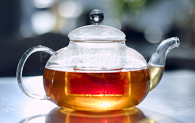 A transparent glass teapot filled with freshly brewed tea. A warm drink to heat up this winter. A natural source of vitamins and minerals that can help fight off sickness and boost your immune system