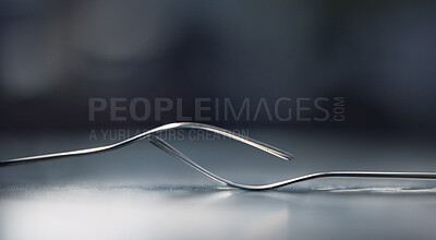 Two forks balanced on on another, symbolizing togetherness, dependency and unity. A symbol of teamwork, relationship and partnership issues and troubles, or dependencies between countries or companies