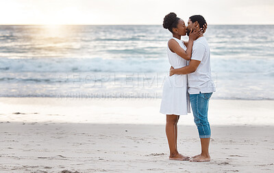 Buy stock photo Fullbody of a happy african American couple spending a day at the sea together. Content boyfriend and girlfriend kissing lovingly on the beach. Caring husband and wife bonding on the seashore
