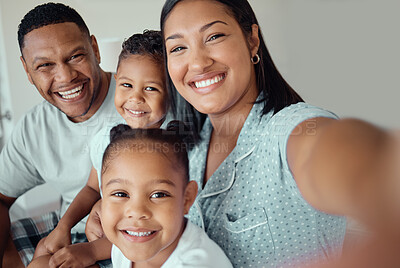 Buy stock photo Photo of a loving mother holding phone and taking selfie or recording funny video with her family at home. Happy mixed race family with two children and parents posing together for a family picture on a mobile phone