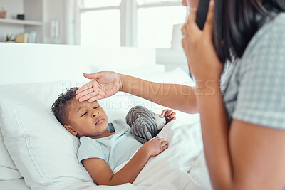 Buy stock photo Sick little boy in bed while his mother talks on the phone calling doctor for help to bring fever down. Young single parent feeling sons forehead to check temperature. Mixed race child feeling ill and lying in bed while his mother checks fever