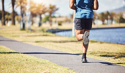 Cropped rearview active fit male doing running exercises alone in a park outside on a sunny day. Muscular legs of a male runner wearing his sportswear. Speed, endurance, stamina and strength training
