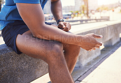 Buy stock photo Closeup of unknown fit active mixed race man taking a break from his workout to breathe and relax. Unrecognizable man exhausted from his jog sitting before doing cardio and focus on his cardio