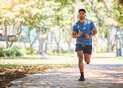 Buy stock photo One active young indian man exercising outdoors. Handsome male athlete enjoying a jog or run for cardio training workout. Determined to build muscle and endurance for fitness and wellness goals