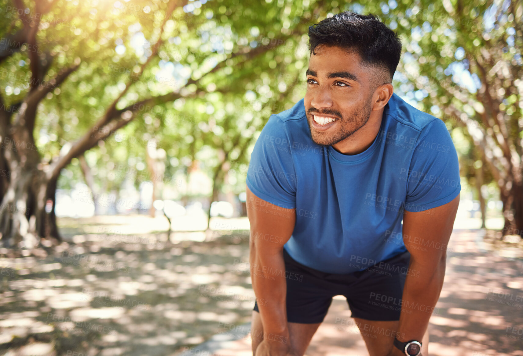 Buy stock photo Fitness, break and man or runner outdoor for exercise, training or running at a park. Happy and tired Indian male athlete in nature for a workout, run and rest while thinking of goals or performance