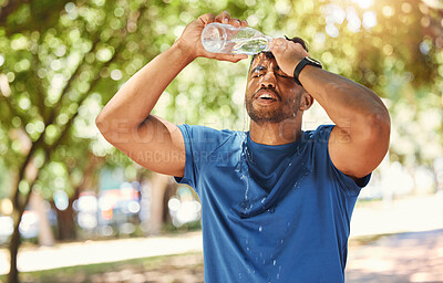 Buy stock photo Fitness, outdoor and a man pouring water on face after exercise, training or running at a park. Tired Indian male athlete in nature for workout, run and break or cooling down with a splash in summer