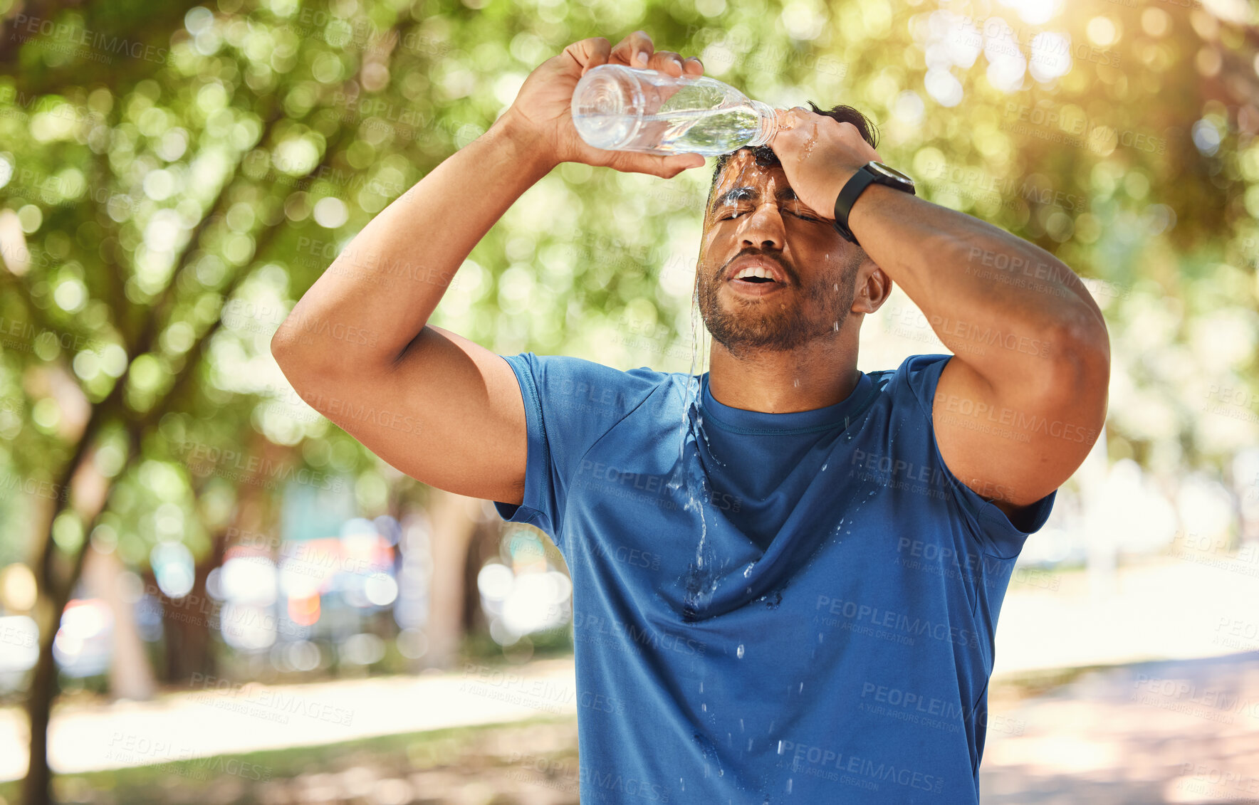 Buy stock photo Fitness, outdoor and a man pouring water on face after exercise, training or running at a park. Tired Indian male athlete in nature for workout, run and break or cooling down with a splash in summer