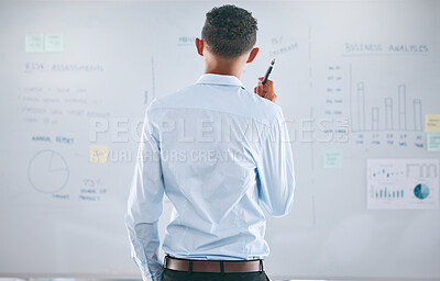 One businessman from behind brainstorming and planning with graphs, stats and analytics on a whiteboard. Mixed race guy thinking of ideas and strategies while doing market research for his startup