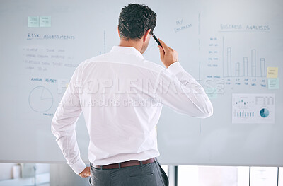 Reaview of an unknown caucasian businessman using a whiteboard to brainstorm in the office. Corporate professional standing alone and thinking strategy and innovation while working on a visual aid