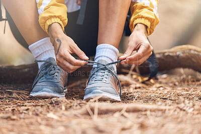 Buy stock photo Closeup shot of an unrecognizable woman tying the laces of her sneakers while out hiking in the woods.Unknown female making sure her shoes and secure while enjoying her weekend with a hike in a forest