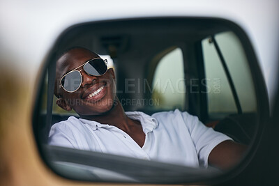 Buy stock photo One African American man looking in the car mirror while taking a roadtrip. Smiling black man enjoying the weekend and taking a trip in a vehicle while wearing sunglasses