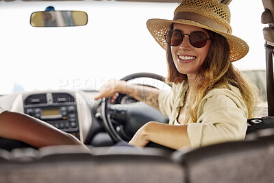 Buy stock photo Portrait of one beautiful caucasian woman holding the steering wheel smiling while taking a road trip to her vacation destination with a friend. Attractive young female hipster with tattoos on her arm, wearing a hat and sunglasses and taking a drive in a car looking happy and relaxed