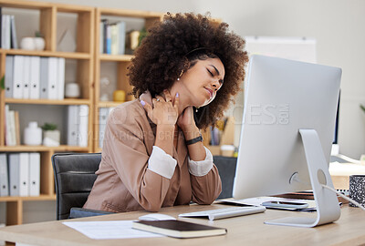 One mixed race African american businesswoman with an afro suffering from a headache while feeling exhausted and depressed at an office job. Stress and anxiety leads to a breakdown at work