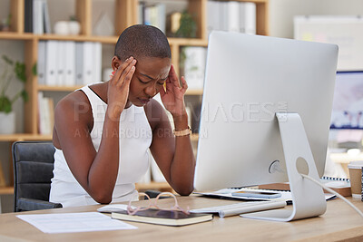 One young African american businesswoman suffering from a headache while feeling exhausted and depressed at an office job while sitting in front of her computer. Stress and anxiety leads to a breakdown at work which makes the mind tired and overworked