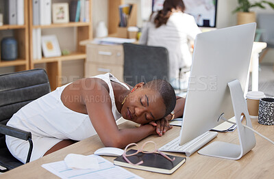 One young african american businesswoman feeling tired and exhausted from her job and sleeping on her desk in the office. Black woman resting during a break at work infront of her computer.