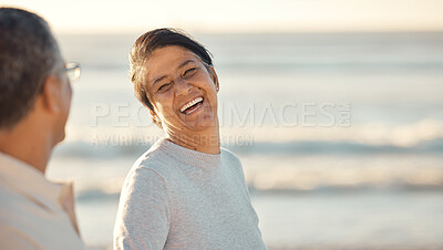 Buy stock photo A senior mixed race couple walking together on the beach  smiling and laughing on a day out at the beach. Hispanic husband and wife looking happy and showing affection while having a romantic day on the beach