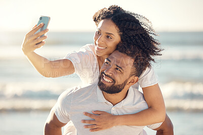 Buy stock photo Couple, piggyback and selfie at beach, smile and happy on holiday with summer sunshine for blog, post and web. Man, woman and photography for romantic vacation, profile picture and social media app